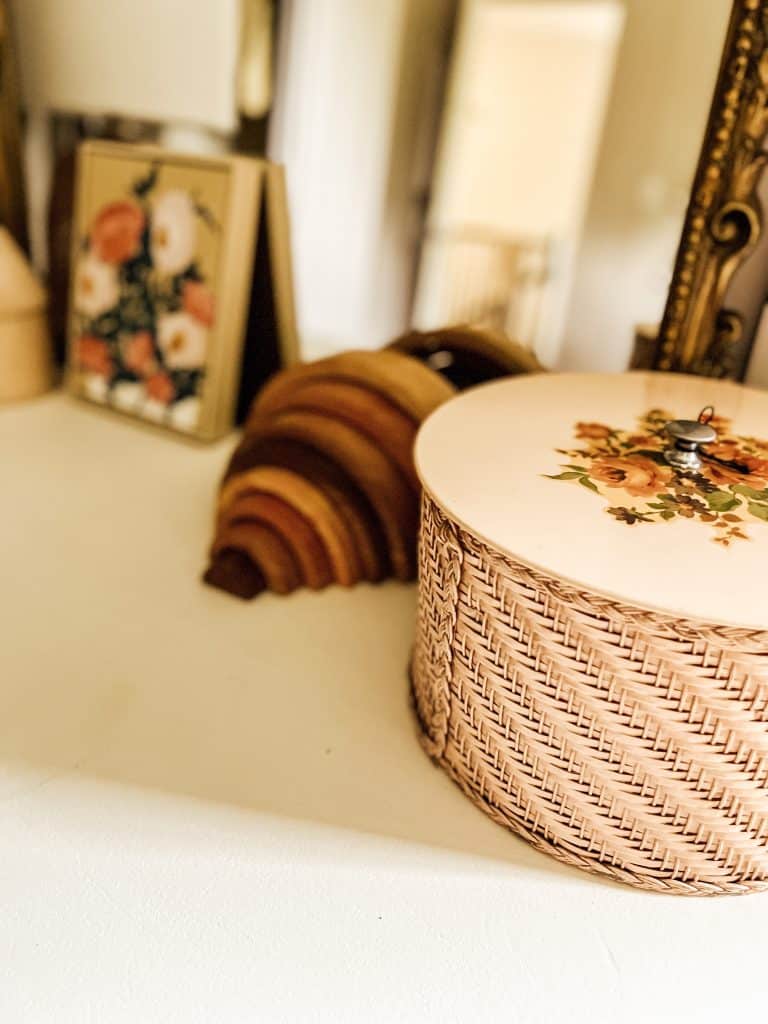Vintage floral sewing box and wooden toys sitting on white dresser