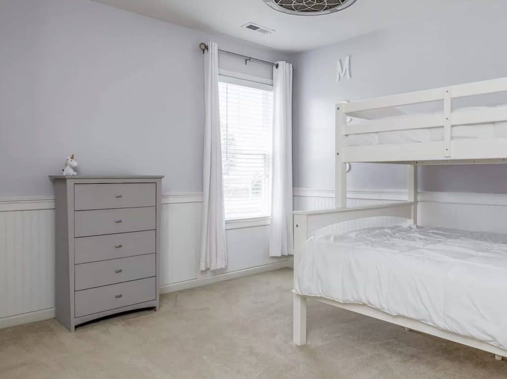 Plain gray room with bunk beds and a dresser